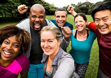 Group of people outside smiling and cheering