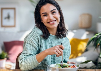 Smiling woman enjoying lunch at home