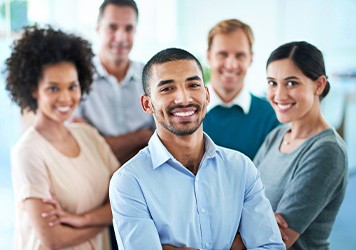 Five professionals standing in front of window overlooking body of water