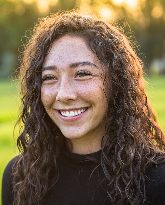 Young brunette woman smiling in the sun