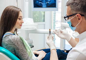 Dentist showing a dental implant to a patient
