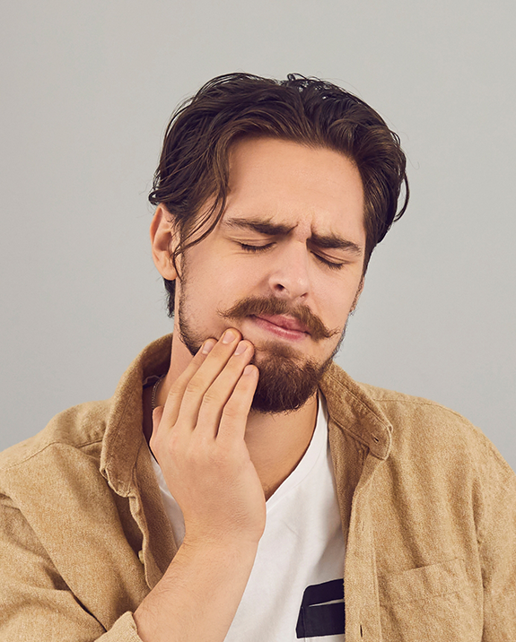 Man holding his jaw in pain and needing an emergency dentist in Ellington
