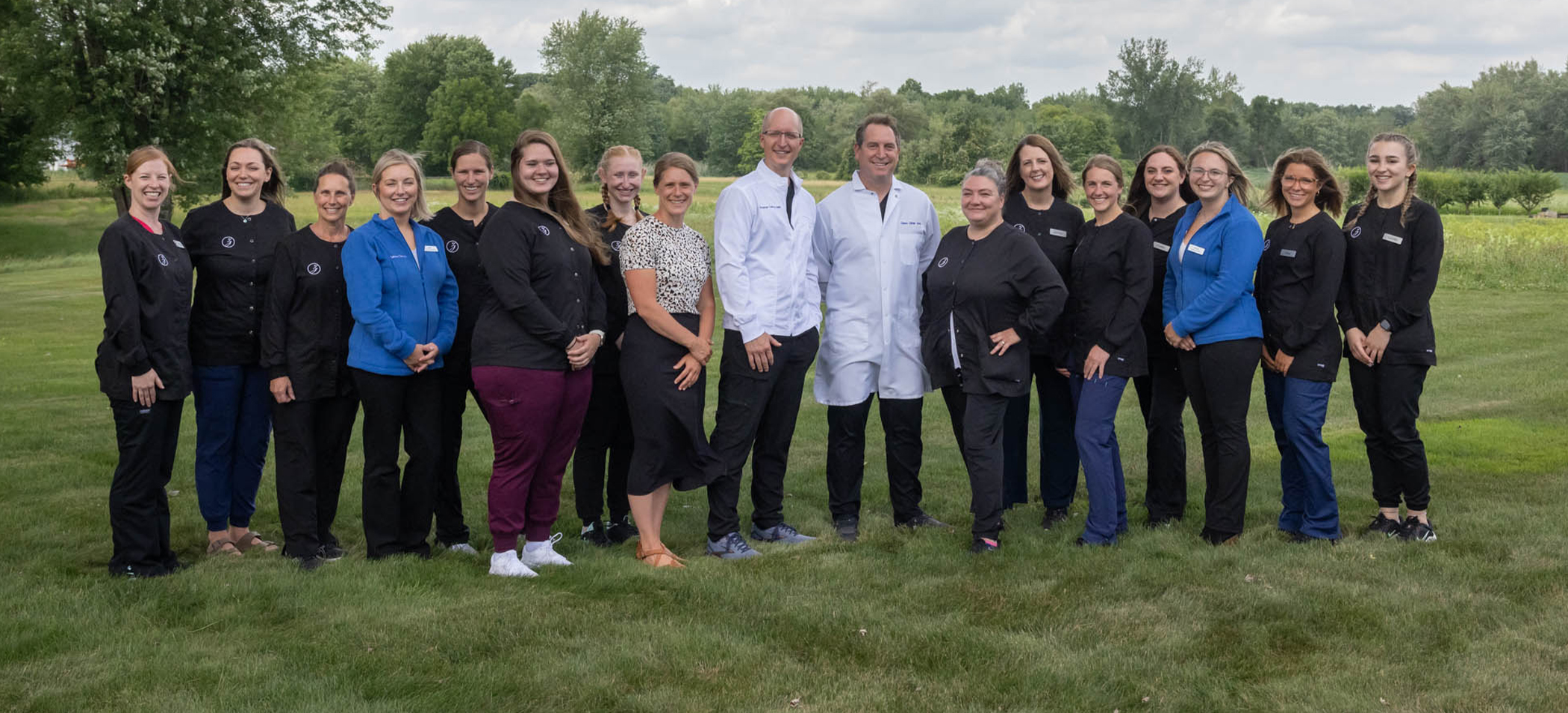 Group photo of the Ellington dentists and team members at Zahner Dental in a field