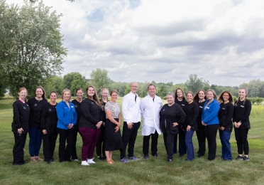 The Zahner Dental team standing in a small field