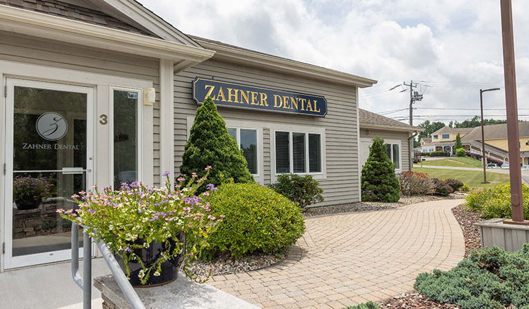Garden and brick walkway leading to the front door of Zahner Dental