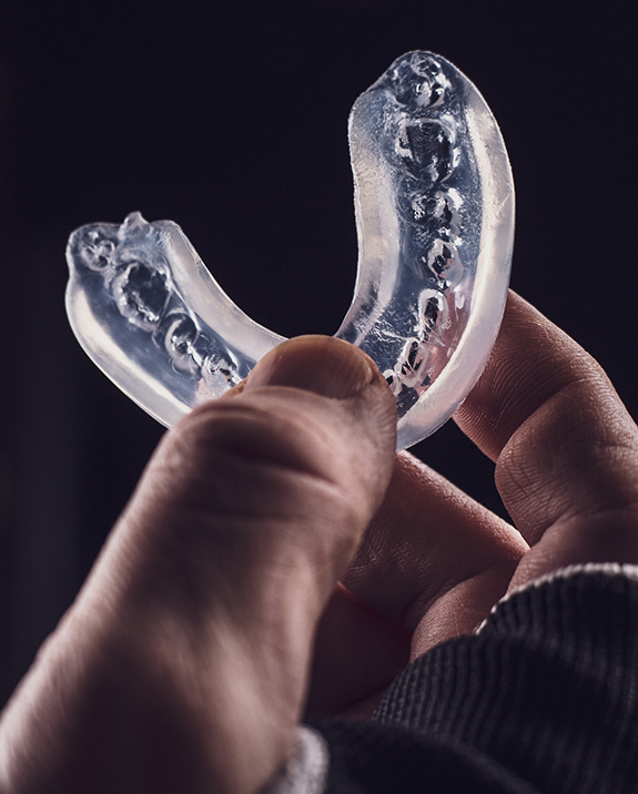 Athlete holding a clear mouthguard