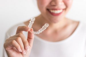 person holding an Invisalign aligner 