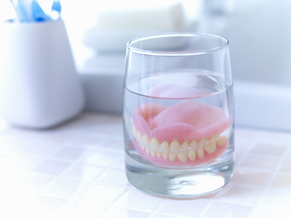 dentures soaking in a cup of water