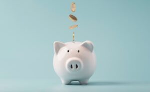 Piggy bank with coins being dropped into it. 