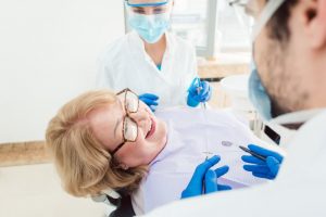 Dental team talking to patient in treatment chair