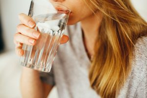 Close up of a woman sipping a glass of water